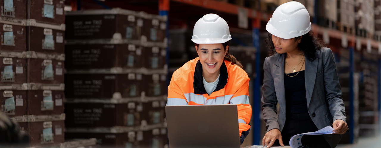 Two technicians have a discussion in a warehouse
